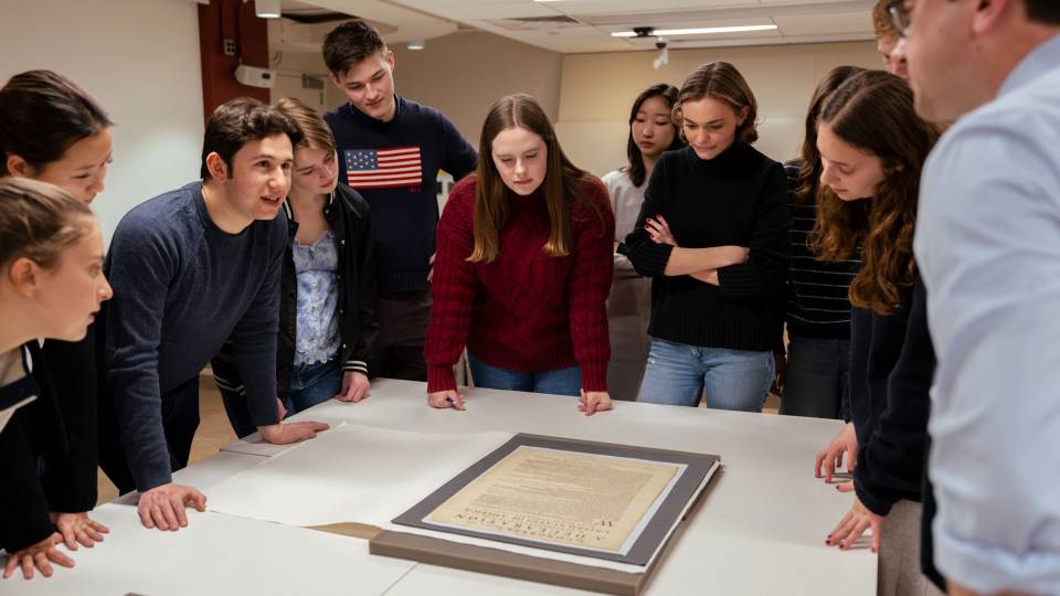 Students examine a rare printing of the Declaration of Independence in a Special Collections classroom