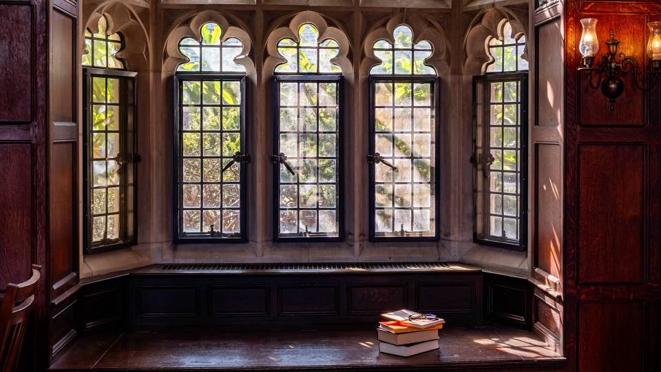 Gothic windows inside a library building with a book in the foreground