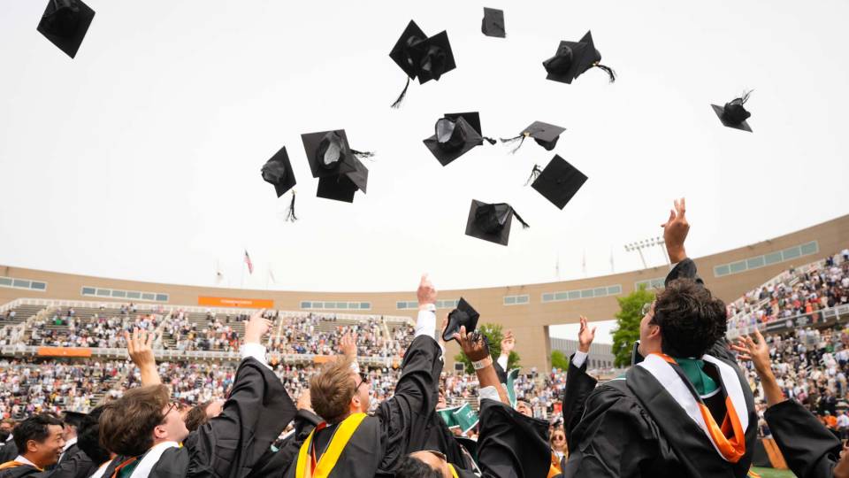 Graduates throw caps in air