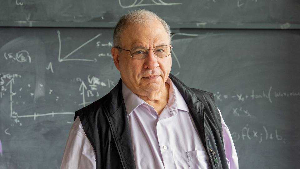 Simon Levin stands before a chalkboard