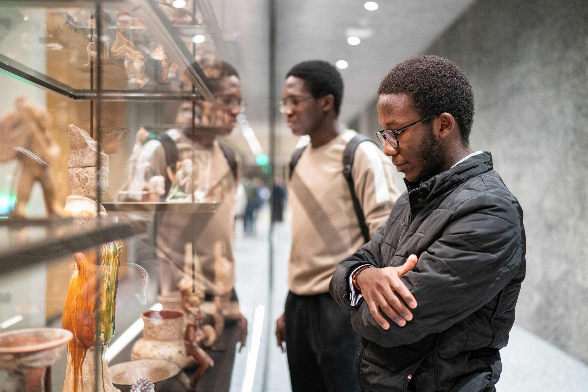Two students look at a display of pottery