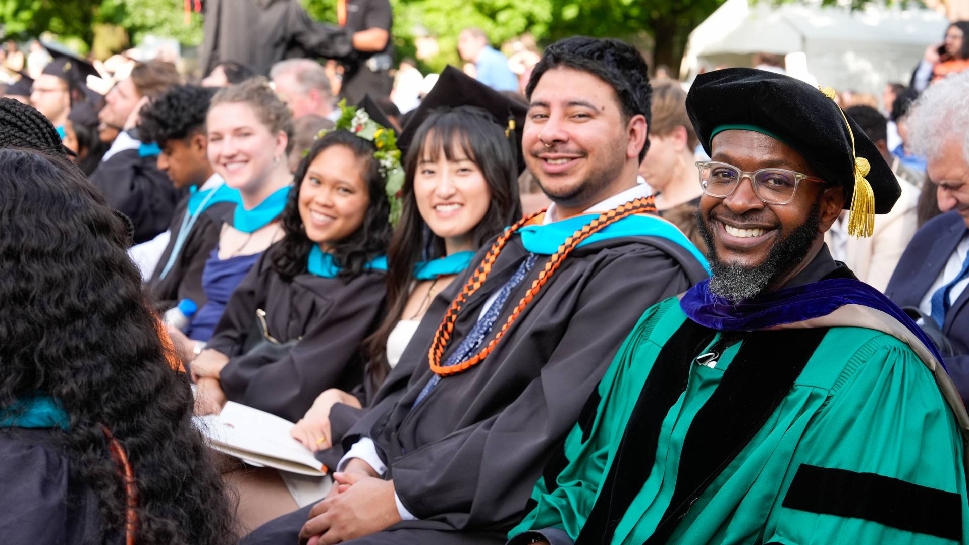 Students and faculty sit in regalia