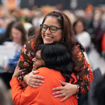 Two employees hug at the Service Recognition Lunch.